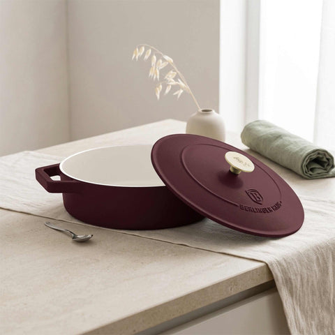 Product image of Shallow pot 26cm cast iron. Part of the Leonardo Collection . Features: • Material: cast iron with 3 layers shiny ENAMEL coating • Size: Ø26*7,5 cm 2,57 L • Color: matt bordeaux- white. (Studio view). Official Berlinger Haus product, boosted by Promintra sl.