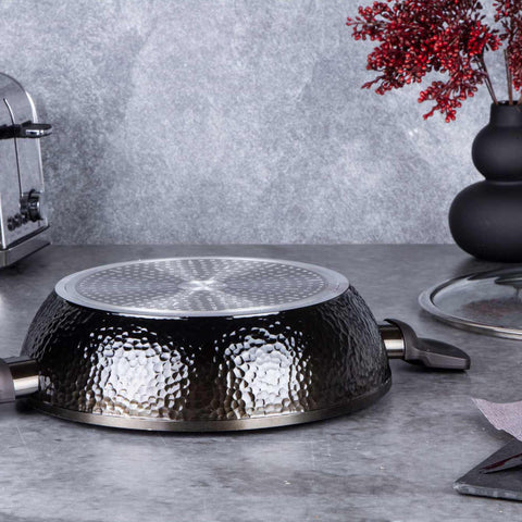 Product image of Shallow pot with lid 28cm. Part of the Primal Gloss Collection . Features: • Material: forged aluminum • Shallow pot with lid Ø28*7,5 cm 3,8L • Color: dark grey with black shadow and shining hammer effect REGISTERED DESIGN.... (Studio view). Official Berlinger Haus product, boosted by Promintra sl.