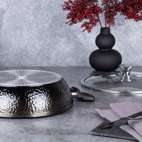 Product image of Shallow pot with lid 28cm. Part of the Primal Gloss Collection . Features: • Material: forged aluminum • Shallow pot with lid Ø28*7,5 cm 3,8L • Color: dark grey with black shadow and shining hammer effect REGISTERED DESIGN.... (Studio view). Official Berlinger Haus product, boosted by Promintra sl.