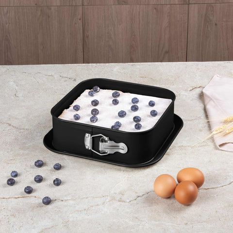 Product image of Square springform 28x28cm. Part of the Matte Black Collection/Black Rose Collection . Features: • Material: carbon steel with non-stick titanPro coating • Size: 23,8*23,8*8 cm • Base size: 28*28 cm • Color: matt black. (Studio view). Official Berlinger Haus product, boosted by Promintra sl.