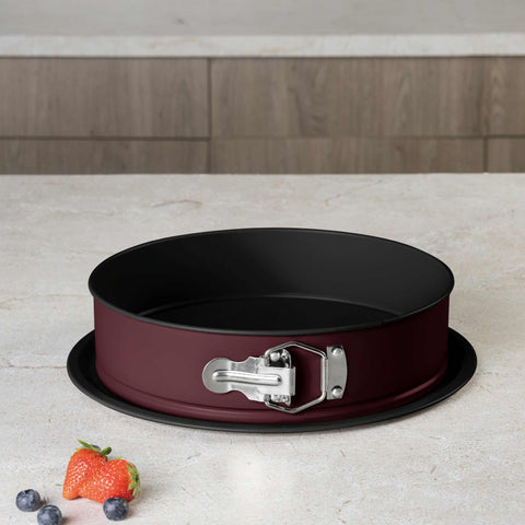 Product image of Round springform 26x6,8cm. Part of the Leonardo Collection . Features: • Material: carbon steel with titanPro non-stick coating • Size: 26*6,8 cm • Base size: Ø29,9 cm • Color: matt bordeaux. (Studio view). Official Berlinger Haus product, boosted by Promintra sl.