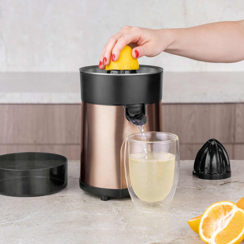 Product image of Juice extractor. Part of the Metallic Line Rose Gold Edition . Features: • Citrus juicer • Material: stainless steel • 85W • Juice cup 300 ml • 2 pcs squeezer attachments • Length of power cord: 80 cm • Color: rose gold. (Studio view). Official Berlinger Haus product, boosted by Promintra sl.