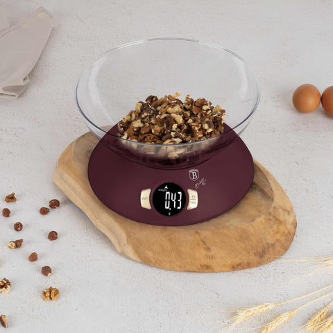 Product image of Kitchen scale with bowl. Part of the Leonardo Collection . Features: • Material: plastic • LCD display • Capacity: 5 kg • AAA battery included • Accessories: • Measuring cup: 25 ml • Egg separator • Color: matt bordeaux. (Studio view). Official Berlinger Haus product, boosted by Promintra sl.
