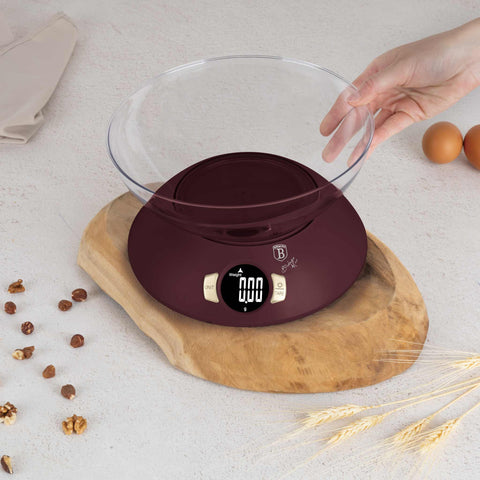 Product image of Kitchen scale with bowl. Part of the Leonardo Collection . Features: • Material: plastic • LCD display • Capacity: 5 kg • AAA battery included • Accessories: • Measuring cup: 25 ml • Egg separator • Color: matt bordeaux. (Studio view). Official Berlinger Haus product, boosted by Promintra sl.