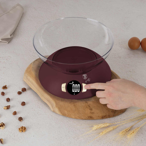 Product image of Kitchen scale with bowl. Part of the Leonardo Collection . Features: • Material: plastic • LCD display • Capacity: 5 kg • AAA battery included • Accessories: • Measuring cup: 25 ml • Egg separator • Color: matt bordeaux. (Studio view). Official Berlinger Haus product, boosted by Promintra sl.