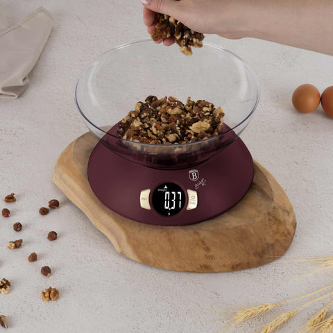 Product image of Kitchen scale with bowl. Part of the Leonardo Collection . Features: • Material: plastic • LCD display • Capacity: 5 kg • AAA battery included • Accessories: • Measuring cup: 25 ml • Egg separator • Color: matt bordeaux. (Studio view). Official Berlinger Haus product, boosted by Promintra sl.