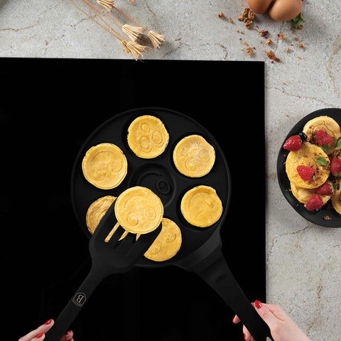 Product image of 7holes emoji pancake pan 26cm. Part of the Matte Black Collection/Black Rose Collection . Features: • Material: cast aluminium • Pancake pan Ø26*1,3 cm • Color: matt black. (Studio view). Official Berlinger Haus product, boosted by Promintra sl.