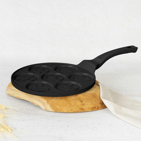Product image of 7holes emoji pancake pan 26cm. Part of the Matte Black Collection/Black Rose Collection . Features: • Material: cast aluminium • Pancake pan Ø26*1,3 cm • Color: matt black. (Studio view). Official Berlinger Haus product, boosted by Promintra sl.