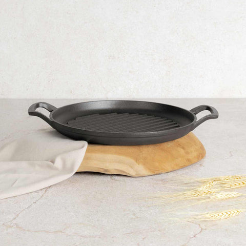 Product image of Round grill plate 33cm cast iron. Part of the Strong Mold Seria . Features: • Material: cast iron with outside/inside oil coating • Size: 32,9*25*2,5 cm 1,95 kg • Color: black. (Studio view). Official Berlinger Haus product, boosted by Promintra sl.