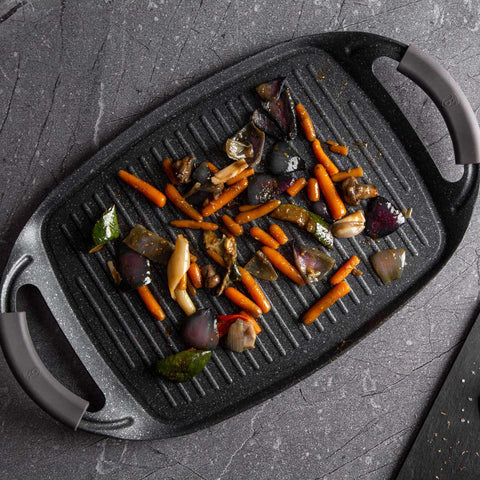 Product image of Grill plate 47cm. Part of the Metallic Line Carbon Pro Edition . Features: • Material: forged aluminum • Size: 47*29 cm • Color: dark grey • FREE 2 PCS HEAT RESISTANT SILICONE HANDLE. (Studio view). Official Berlinger Haus product, boosted by Promintra sl.