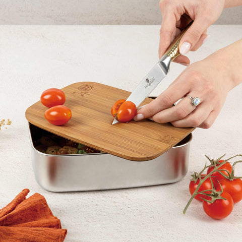 Product image of Lunch box with bamboo lid. Part of the kitchen accessories . Features: • Material: 18/10 stainless steel, bamboo • Size: 21,2*15,8*7 cm • Capacity: 1500 ml • 2 in 1: bamboo lid and cutting board • Silicone elastic strap. (Studio view). Official Berlinger Haus product, boosted by Promintra sl.