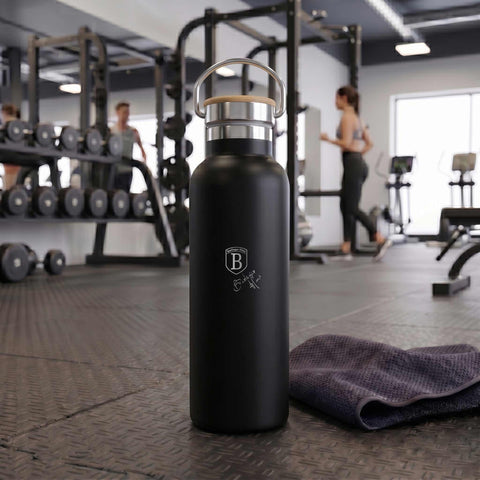 Product image of Flask with bamboo lid 0,6L. Part of the Matte Black Collection . Features: • Material: 18/10 stainless steel with matt powder coating • Bamboo lid • Capacity: 0,6 L • Color: black- silver • Packing: giftbox. (Studio view). Official Berlinger Haus product, boosted by Promintra sl.