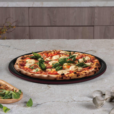 Product image of Pizza pan 32cm. Part of the Leonardo Collection . Features: • Material: carbon steel with titanPro non-stick coating • Size: 32*1,1 cm • Color: matt bordeaux. (Studio view). Official Berlinger Haus product, boosted by Promintra sl.