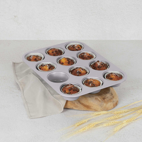 Product image of 12cups muffin pan. Part of the Taupe Collection . Features: • Material: carbon steel with titanPro non-stick coating • Size: 35*26,5*3 cm • Color: matt taupe. (Studio view). Official Berlinger Haus product, boosted by Promintra sl.