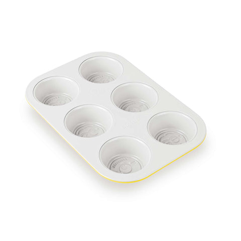 Product image of 6cups muffin pan with pasty bag. Part of the Minions Collection . Features: • Material: carbon steel with titanPro non-stick coating • Size: 26,5*18,5*2,5 cm • Pastry bag with 4 decorating tips • Color: yellow. (Studio view). Official Berlinger Haus product, boosted by Promintra sl.