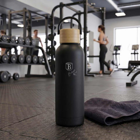 Product image of Vacuum flask with bamboo lid 0,5L. Part of the Matte Black Collection . Features: • Material: 18/10 stainless steel with matt powder coating • Bamboo lid • Capacity: 0,5 L • Color: black • Packing: giftbox. (Studio view). Official Berlinger Haus product, boosted by Promintra sl.