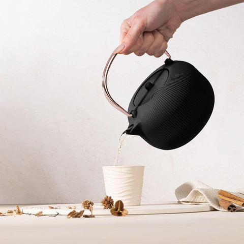 Product image of Cast iron tea pot 1L. Part of the Black Rose Collection . Features: • Material: cast iron • Inside: enamel coating • Capacity: 1L • Removable 18/10 stainless steel filter • Color: black- rose gold. (Studio view). Official Berlinger Haus product, boosted by Promintra sl.