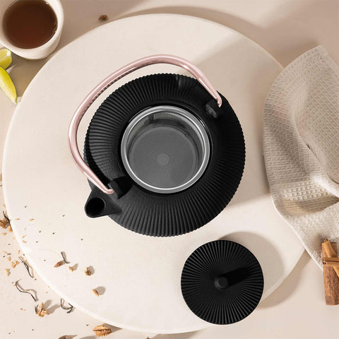 Product image of Cast iron tea pot 1L. Part of the Black Rose Collection . Features: • Material: cast iron • Inside: enamel coating • Capacity: 1L • Removable 18/10 stainless steel filter • Color: black- rose gold. (Studio view). Official Berlinger Haus product, boosted by Promintra sl.