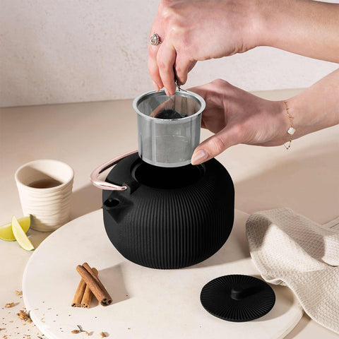Product image of Cast iron tea pot 1L. Part of the Black Rose Collection . Features: • Material: cast iron • Inside: enamel coating • Capacity: 1L • Removable 18/10 stainless steel filter • Color: black- rose gold. (Studio view). Official Berlinger Haus product, boosted by Promintra sl.