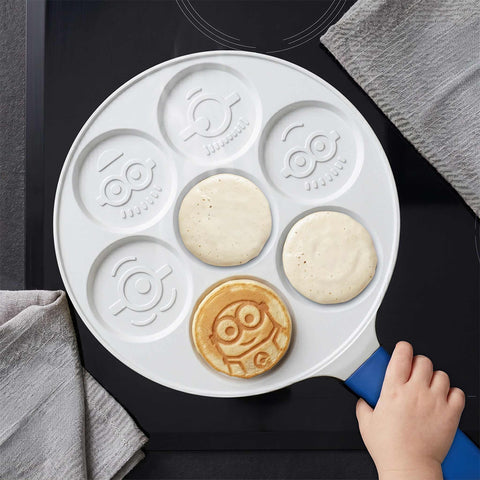Product image of 7holes emoji pancake pan 26cm. Part of the Minions Collection . Features: • Material: cast aluminum • Pancake pan Ø26*1,7 cm • Color: yellow- blue. (Studio view). Official Berlinger Haus product, boosted by Promintra sl.